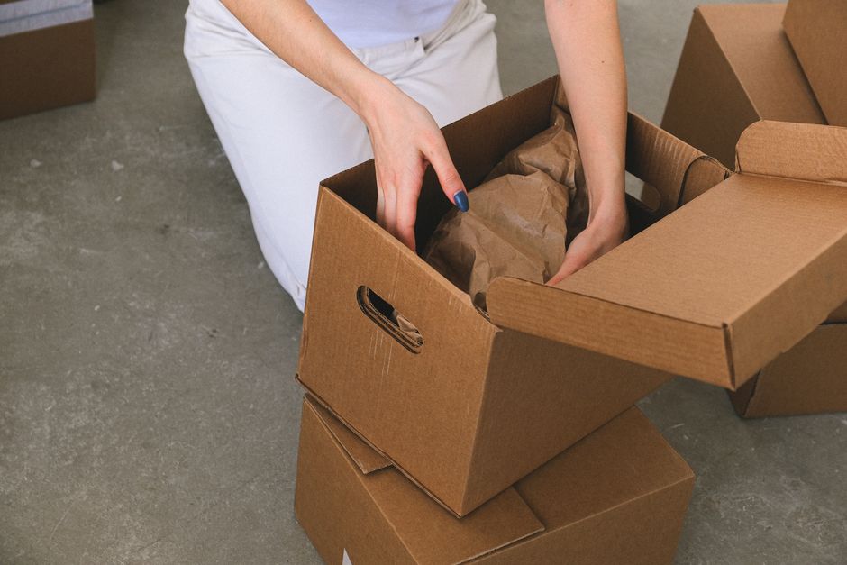 Movers packing cardboard moving boxes