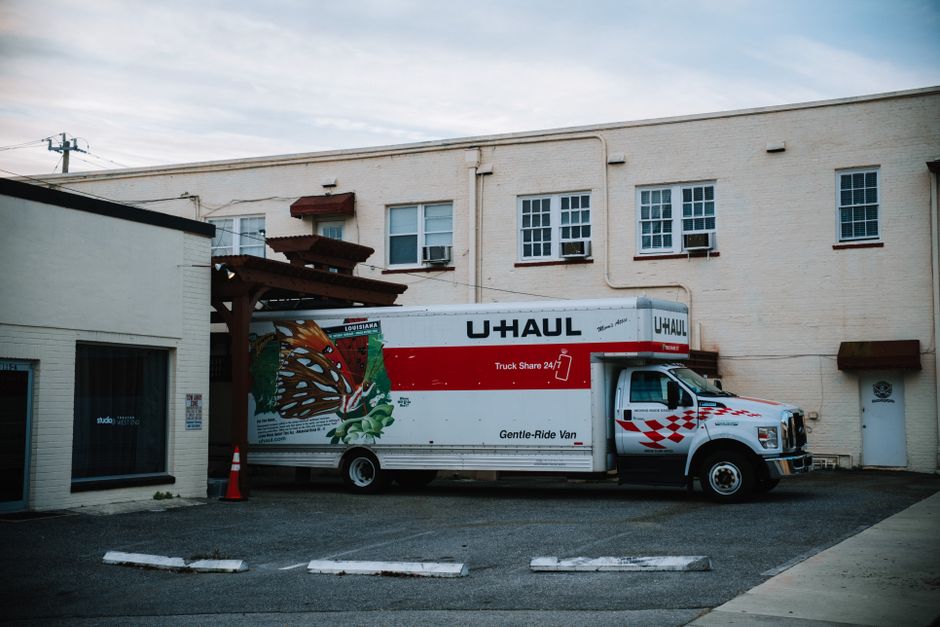 Movers loading heavy furniture into a moving truck